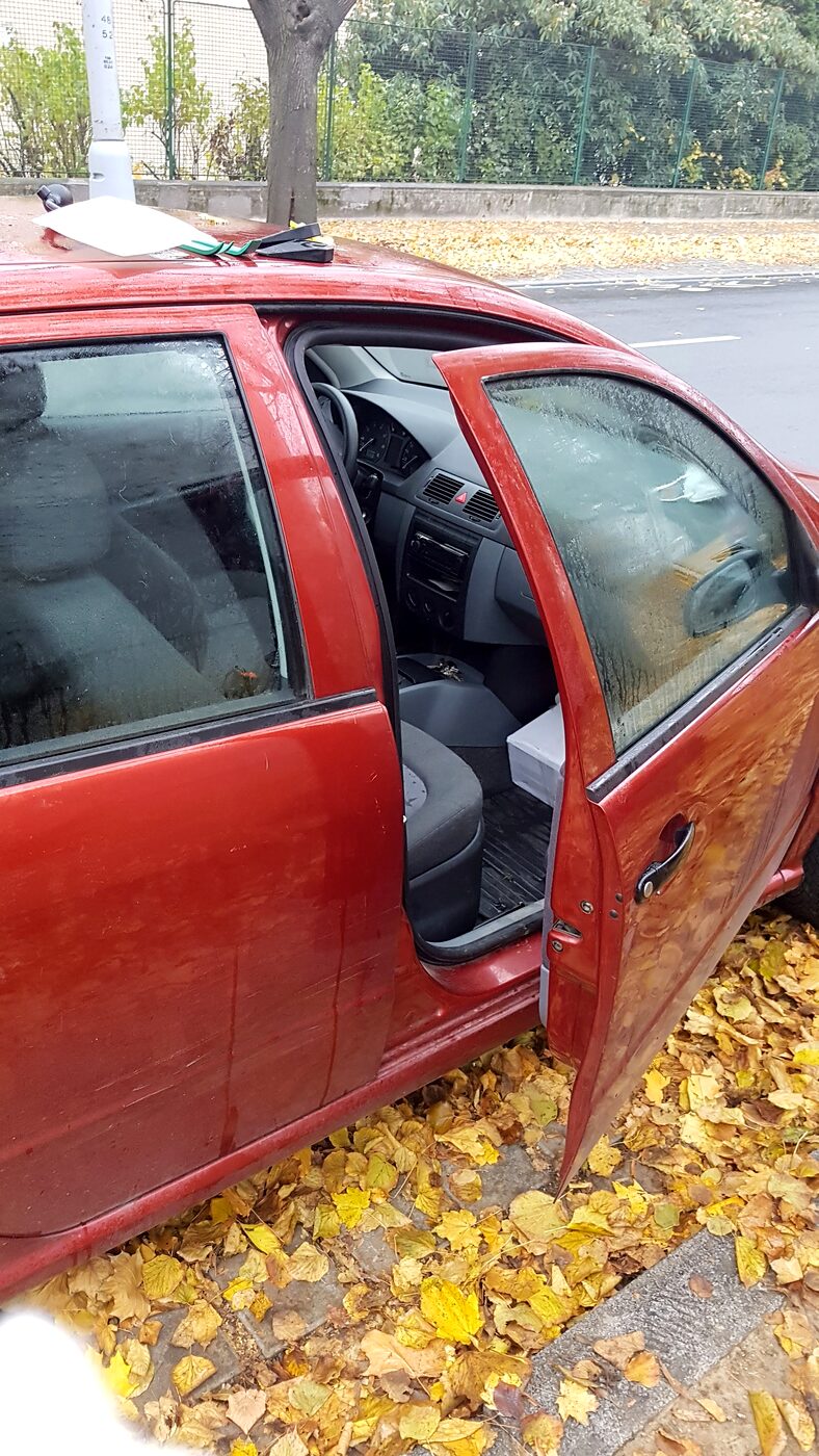Otevřené dveře červeného auta na ulici